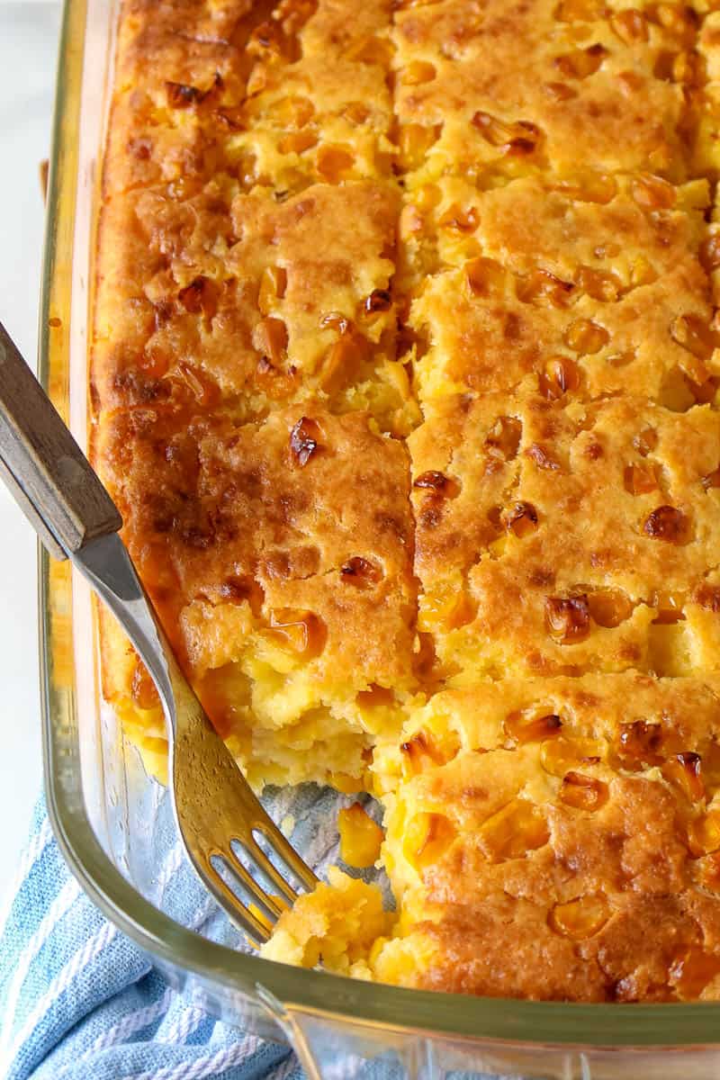 corn pudding in a casserole dish with a fork