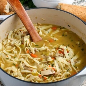 leftover turkey soup in a dutch oven with a wooden soup