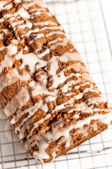 cinnamon swirl bread with a vanilla glaze sitting on a metal cooling rack
