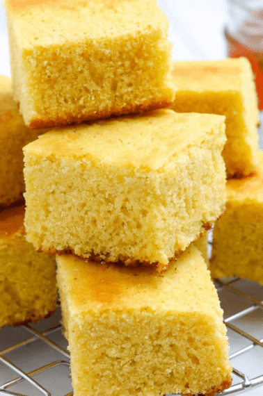 stacked square slices of homemade cornbread on a wire cooling rack