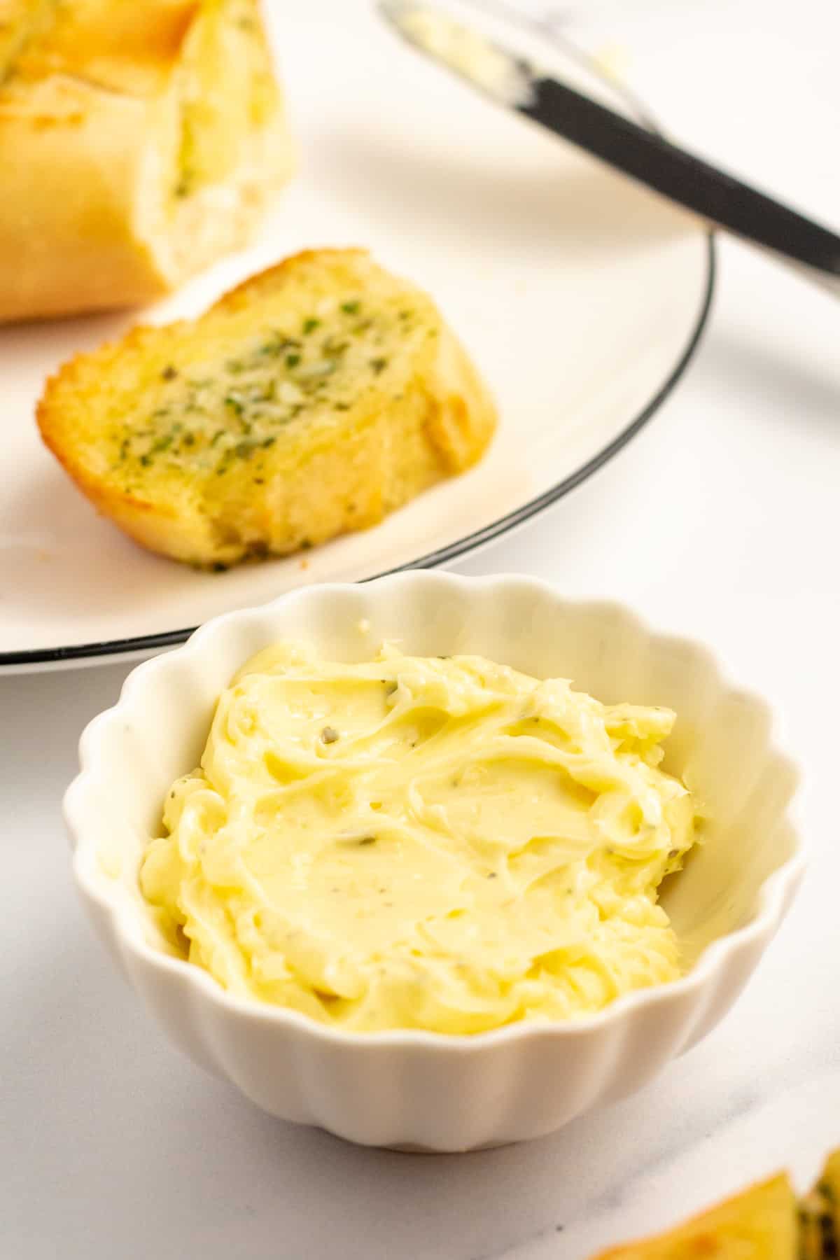 garlic butter served in a small white bowl