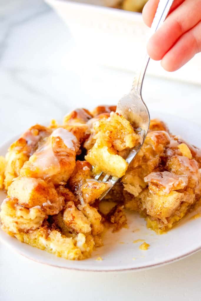 serving of cinnamon roll french toast casserole on a plate with a silver fork