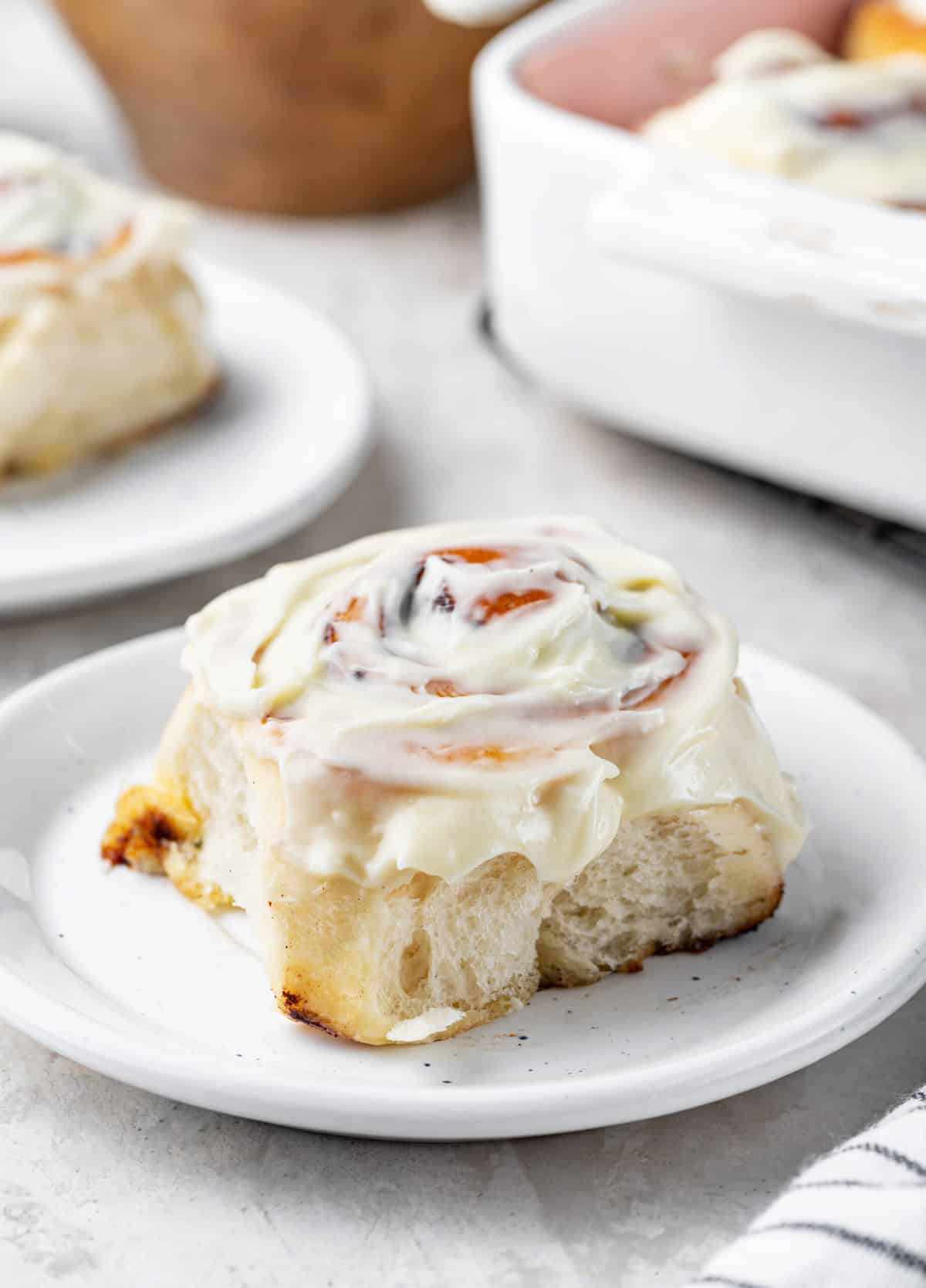 serving a homemade cinnamon rolls with cream cheese frosting on a plate