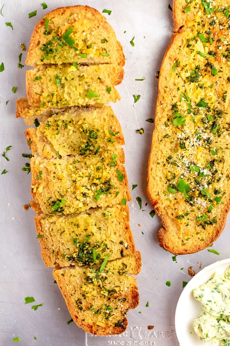 top down image of garlic bread with homemade garlic butter topped with parsley