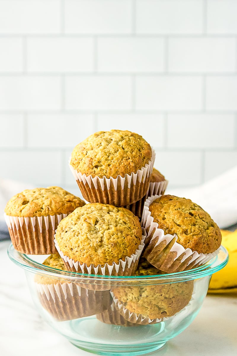 baked banana muffins stacked in a glass bowl