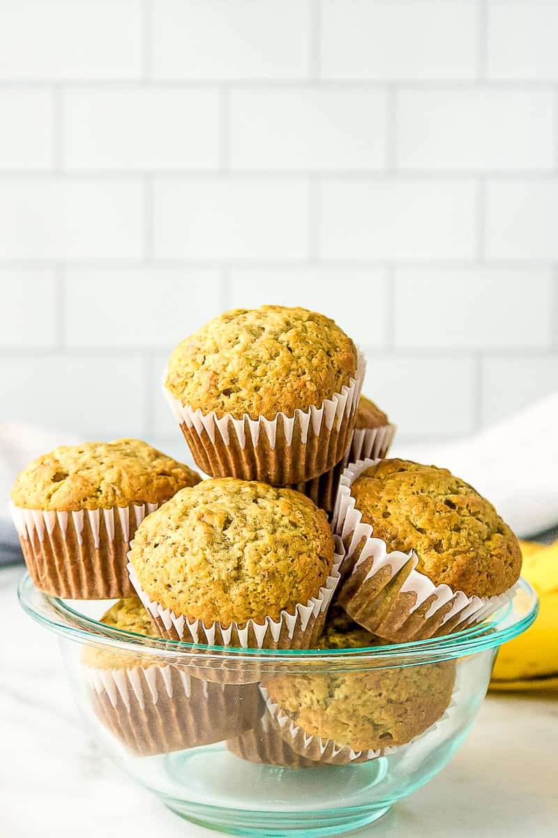 baked banana muffins stacked in a glass bowl