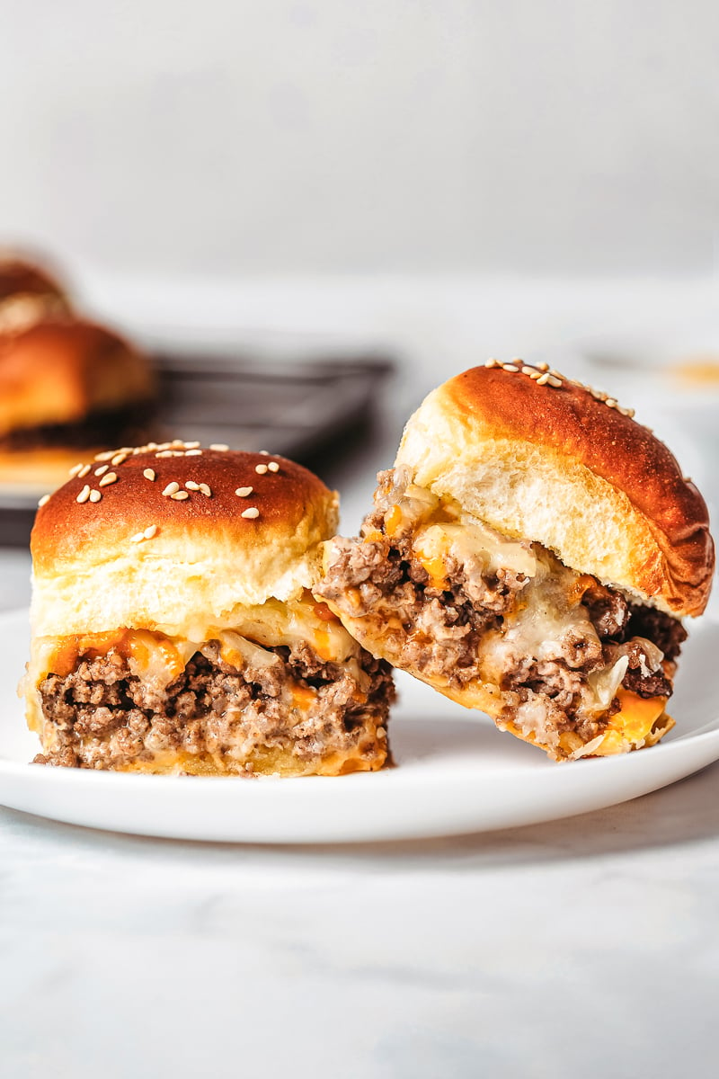 two cheeseburger sliders served on a plate