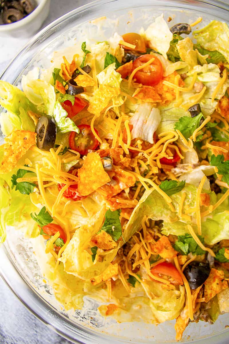 doritos taco salad mixed and served in a round glass bowl