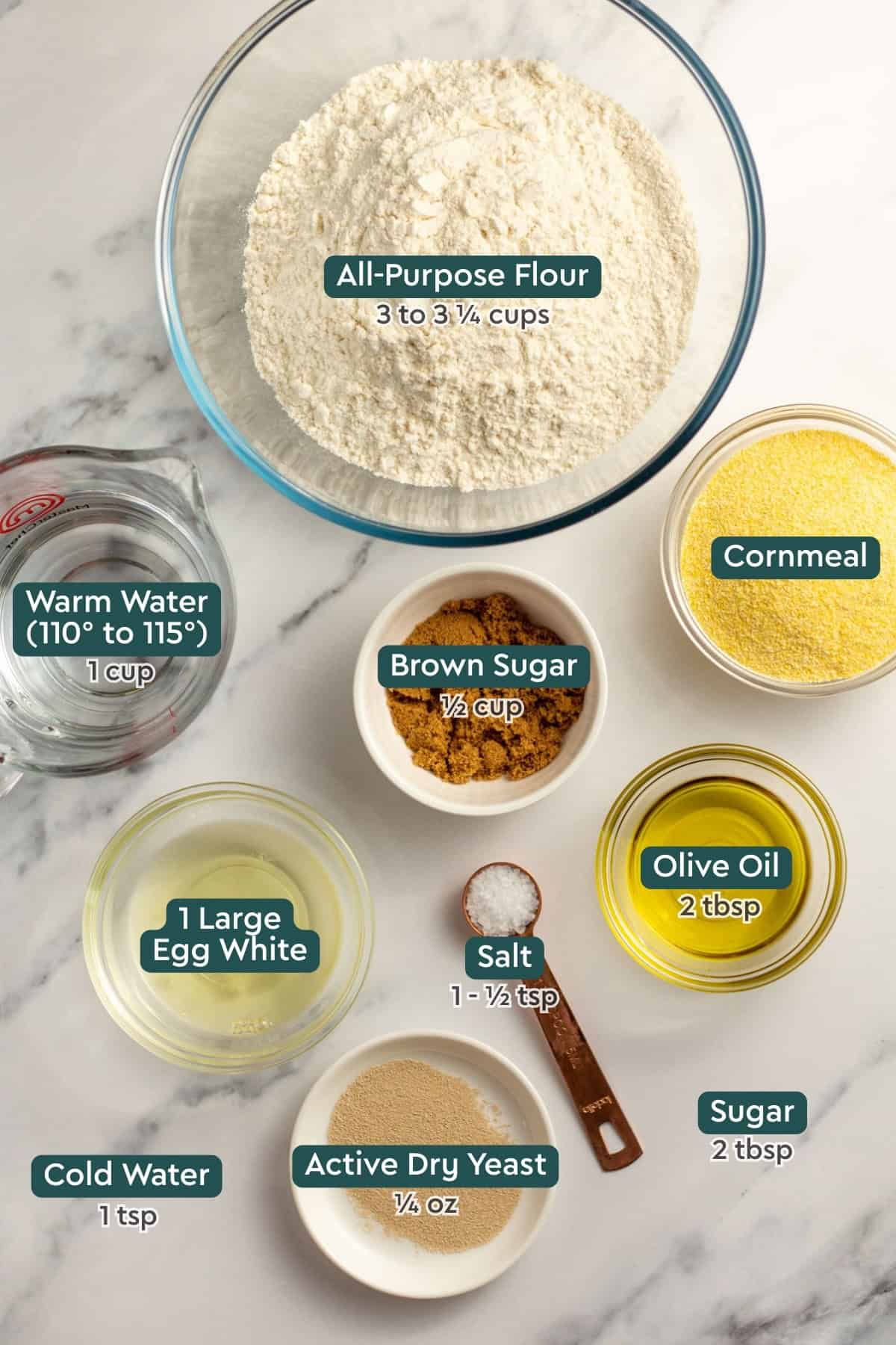 Ingredients for easy French bread, including flour, cornmeal, brown sugar, water, egg white, salt, oil, sugar, yeast.
