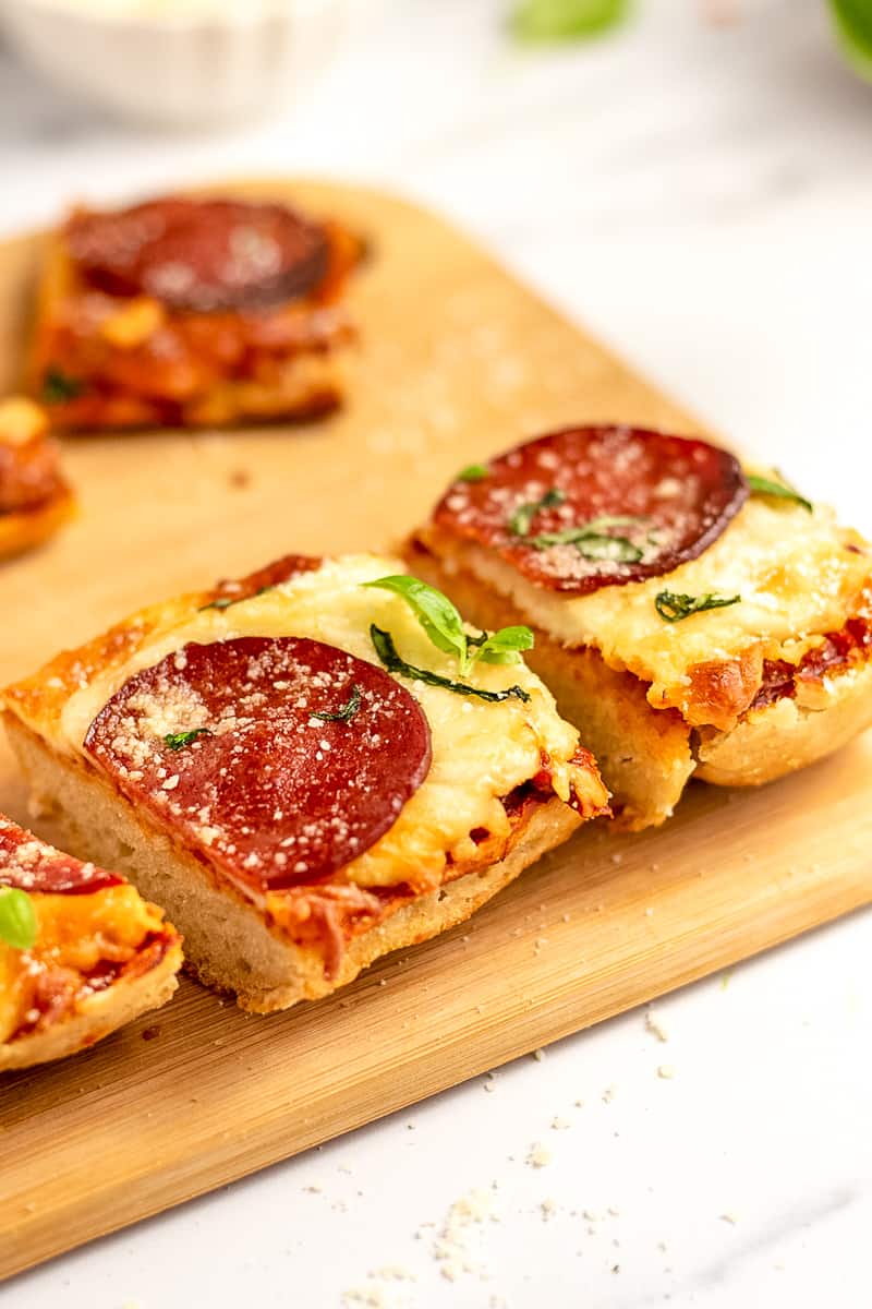 sliced homemade french bread pizza on a wooden platter