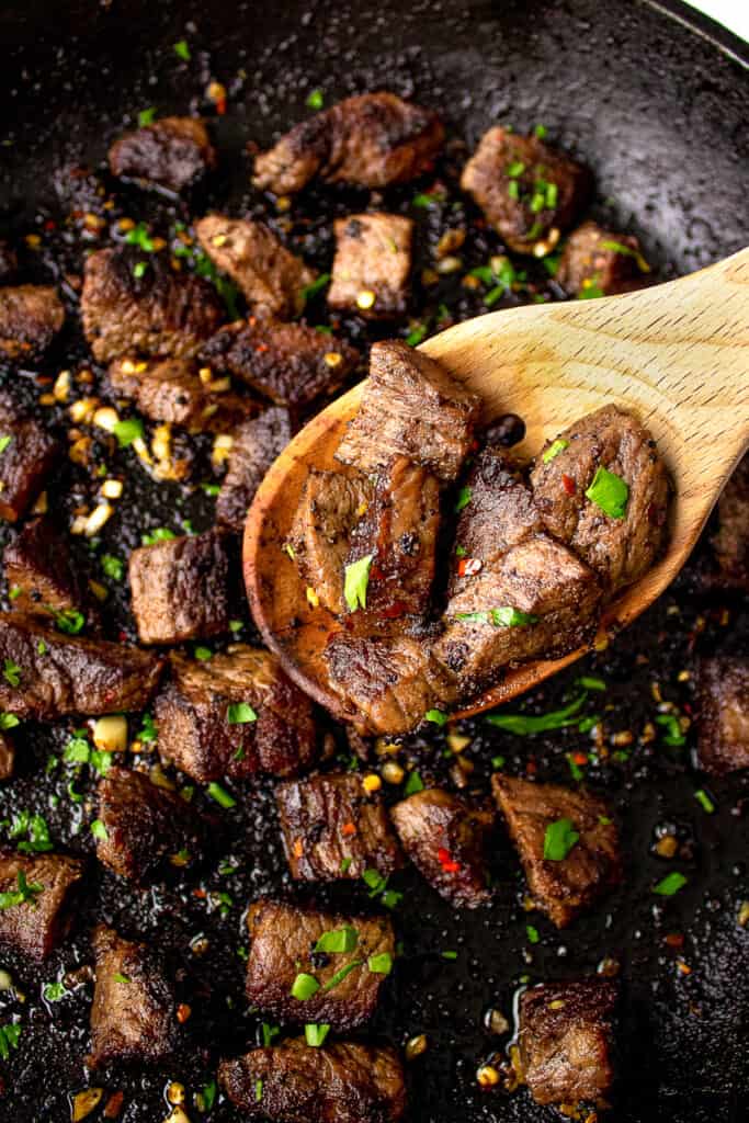 garlic butter steak bites on a wooden spoon