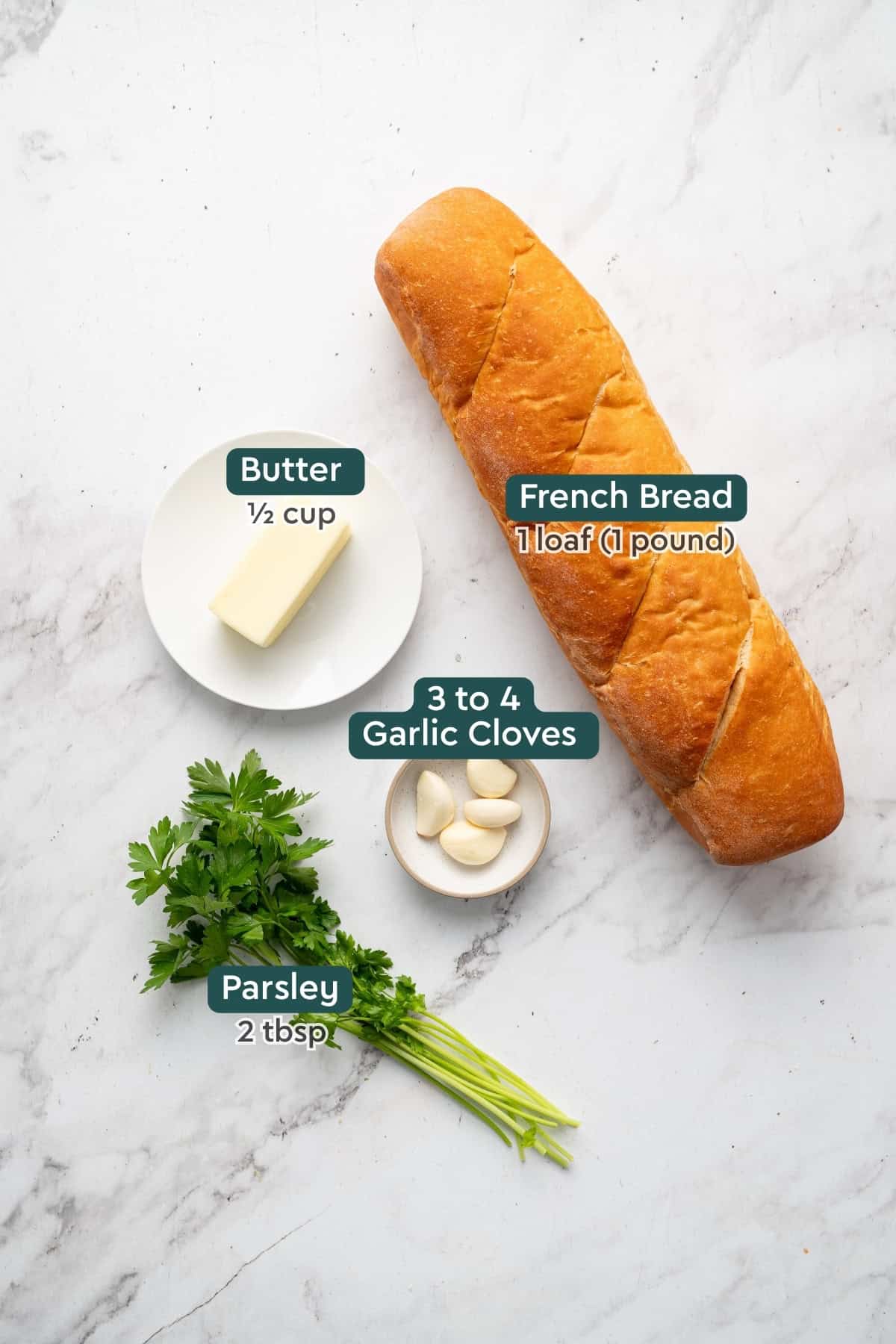 All of the ingredients for homemade garlic bread in bowls on a countertop.