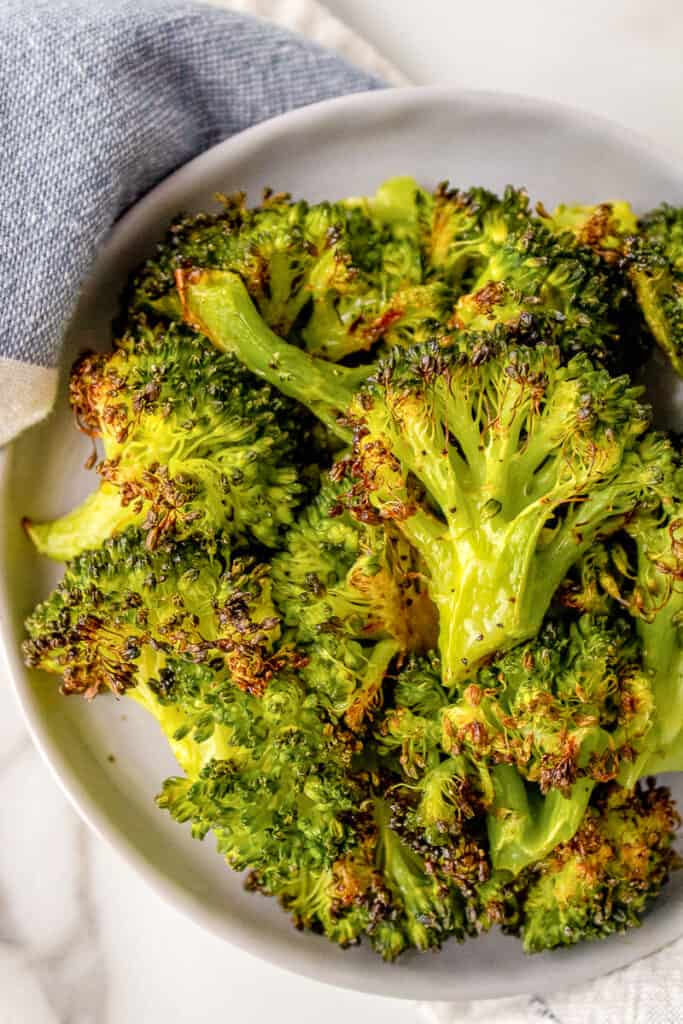 A plate full of roasted frozen broccoli.