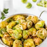 smashed brussel sprouts in a metal bowl with handles