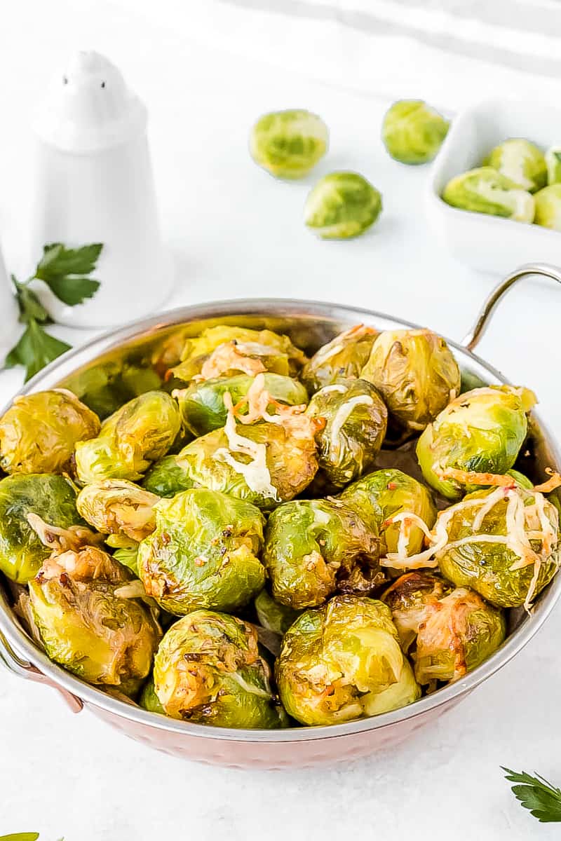 smashed brussel sprouts in a metal bowl with handles