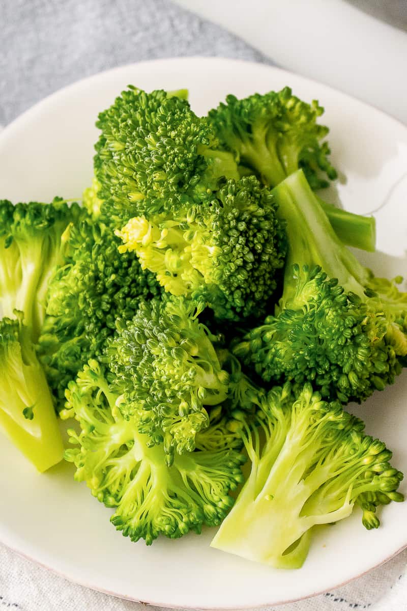 steamed broccoli served on a white plate