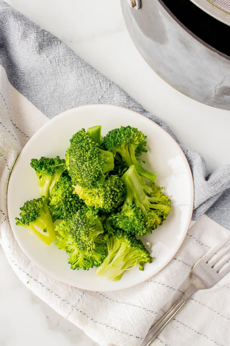 steamed broccoli served on a white plate