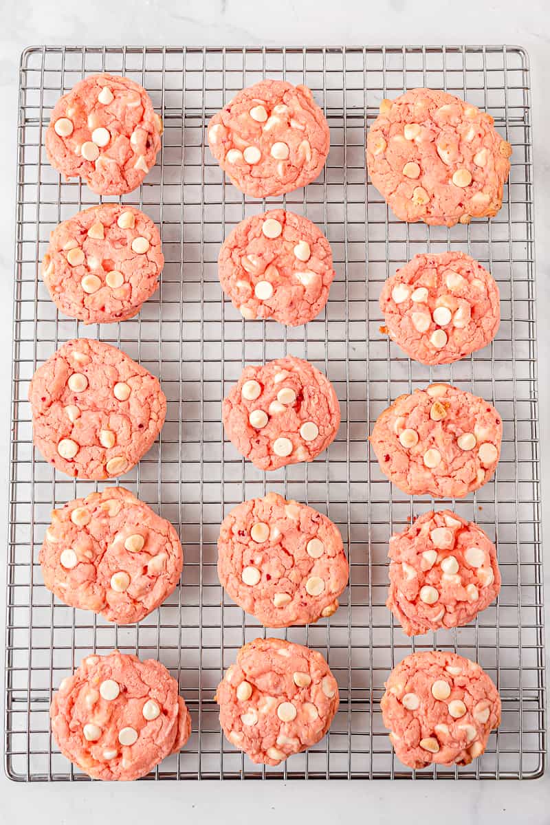 fifteen strawberry cake mix cookies on a wire rack