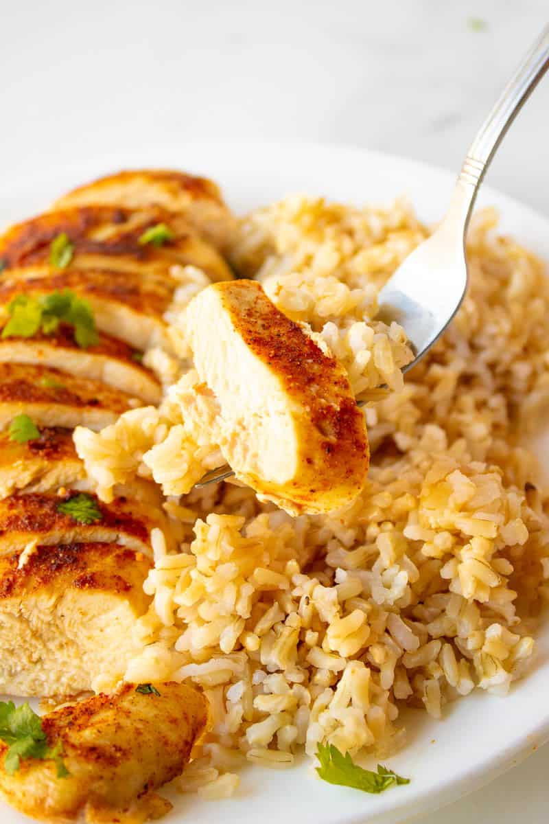 chicken breasts cut with rice on a white plate