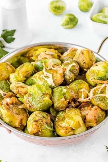 smashed brussel sprouts in a metal bowl with handles