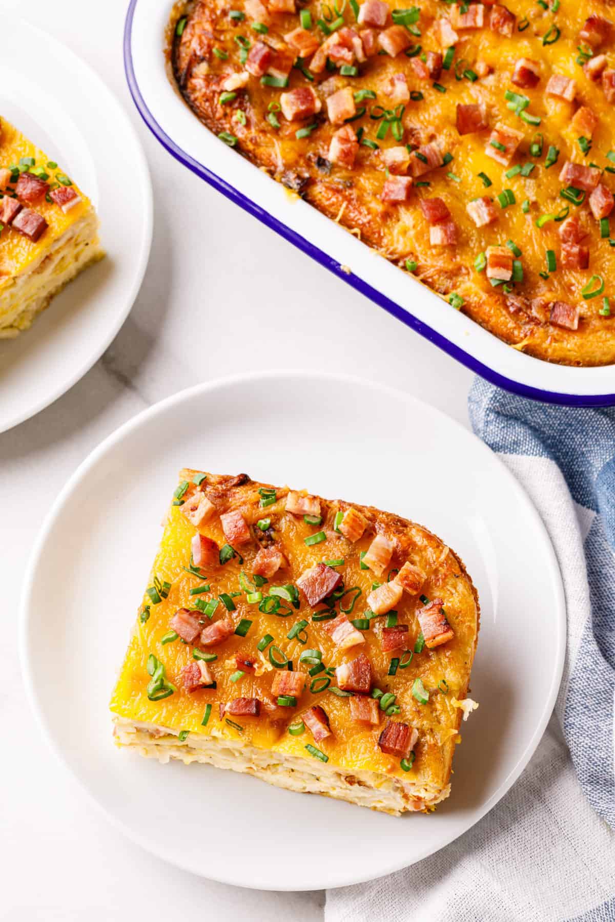 corner serving square of bisquick breakfast casserole with bacon on a white round plate