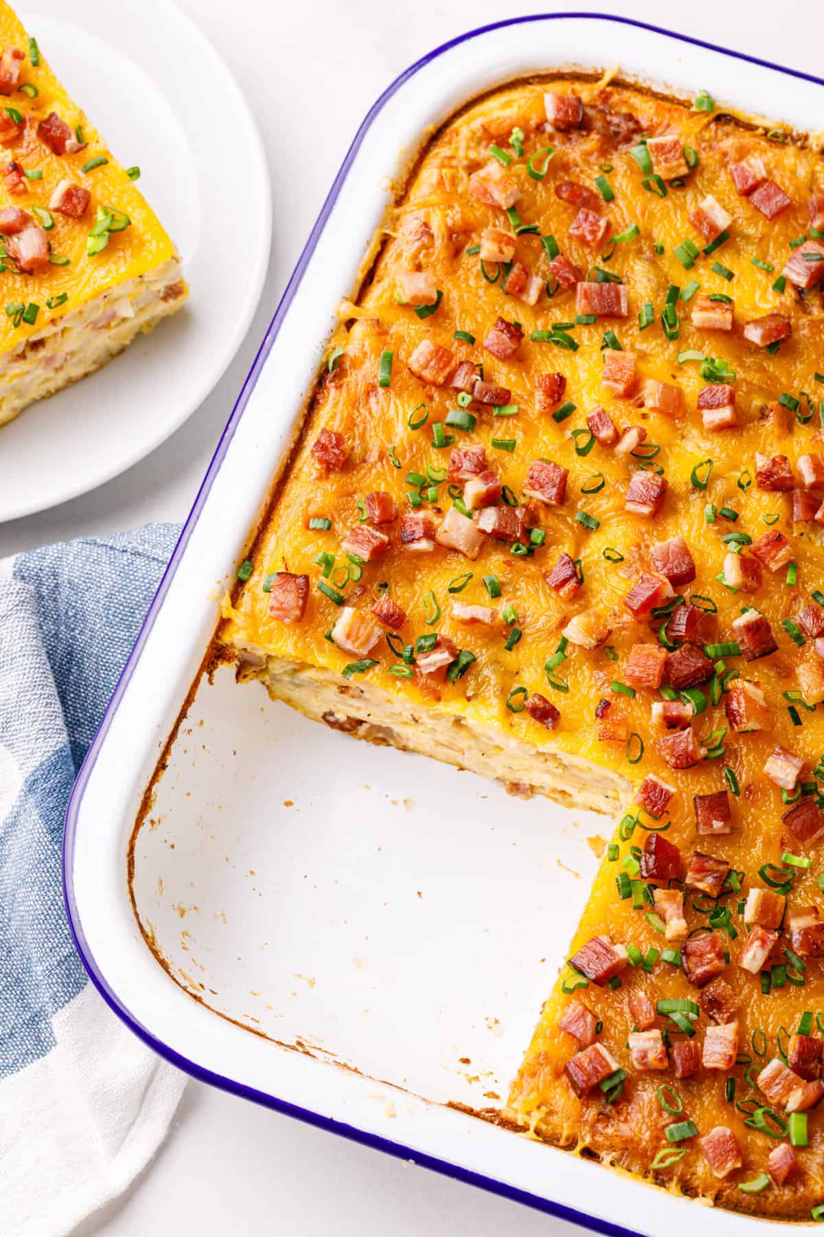bisquick breakfast casserole made with bacon baked in a casserole dish with a serving taken out