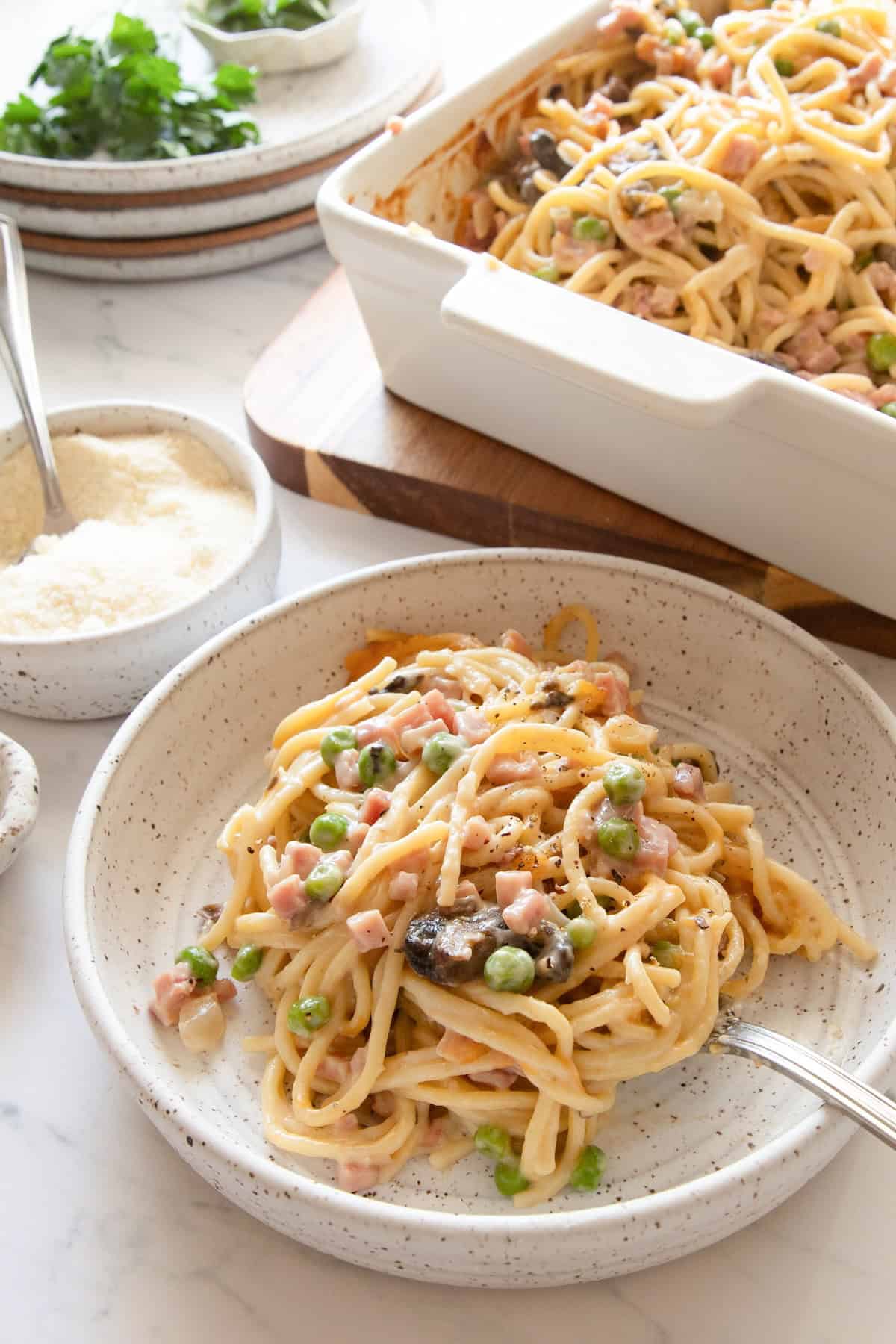 Ham tetrazzini in bowl with casserole dish in background