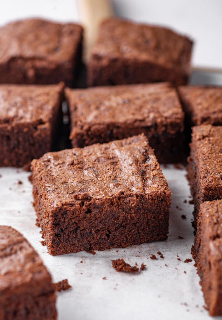 A cut brownie is surrounded by more brownies.