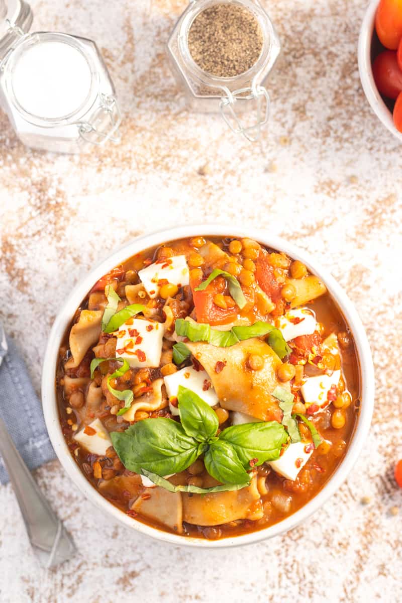 top down image of a bowl of instant pot lasagna soup garnished with fresh basil