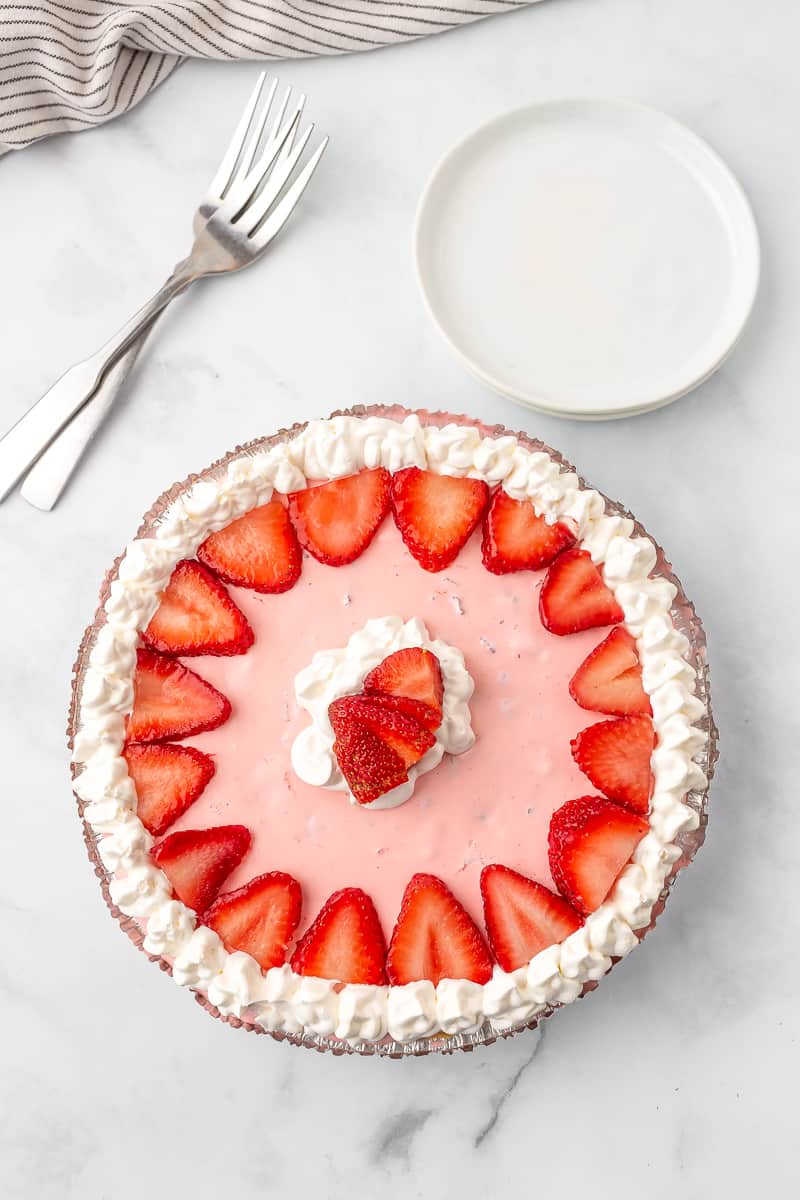 no bake strawberry jello pie topped with sliced strawberries and whipped topping