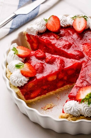 A strawberry pie with a slice missing.