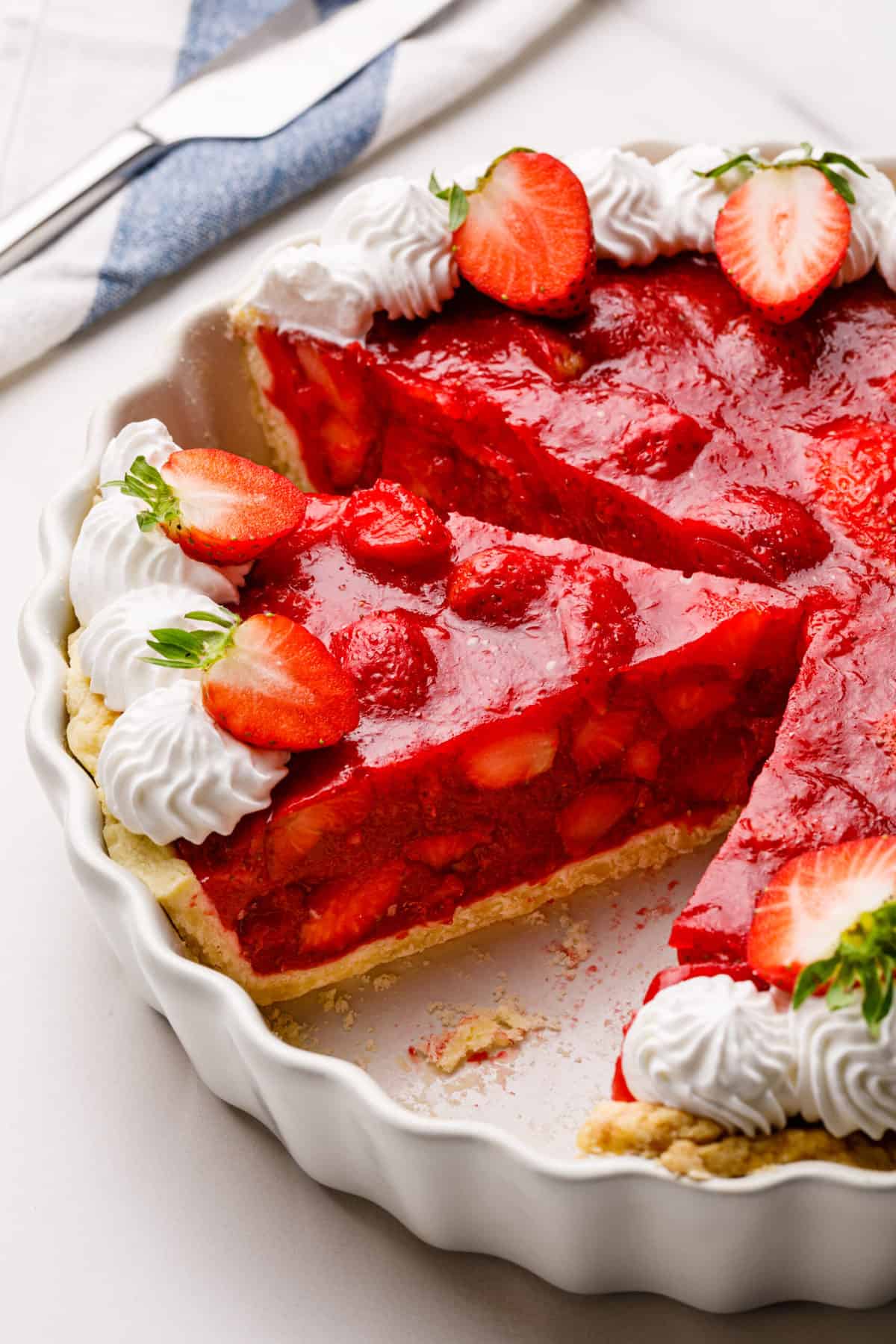 strawberry pie in a pie dish with a slice taken out showing the cross section