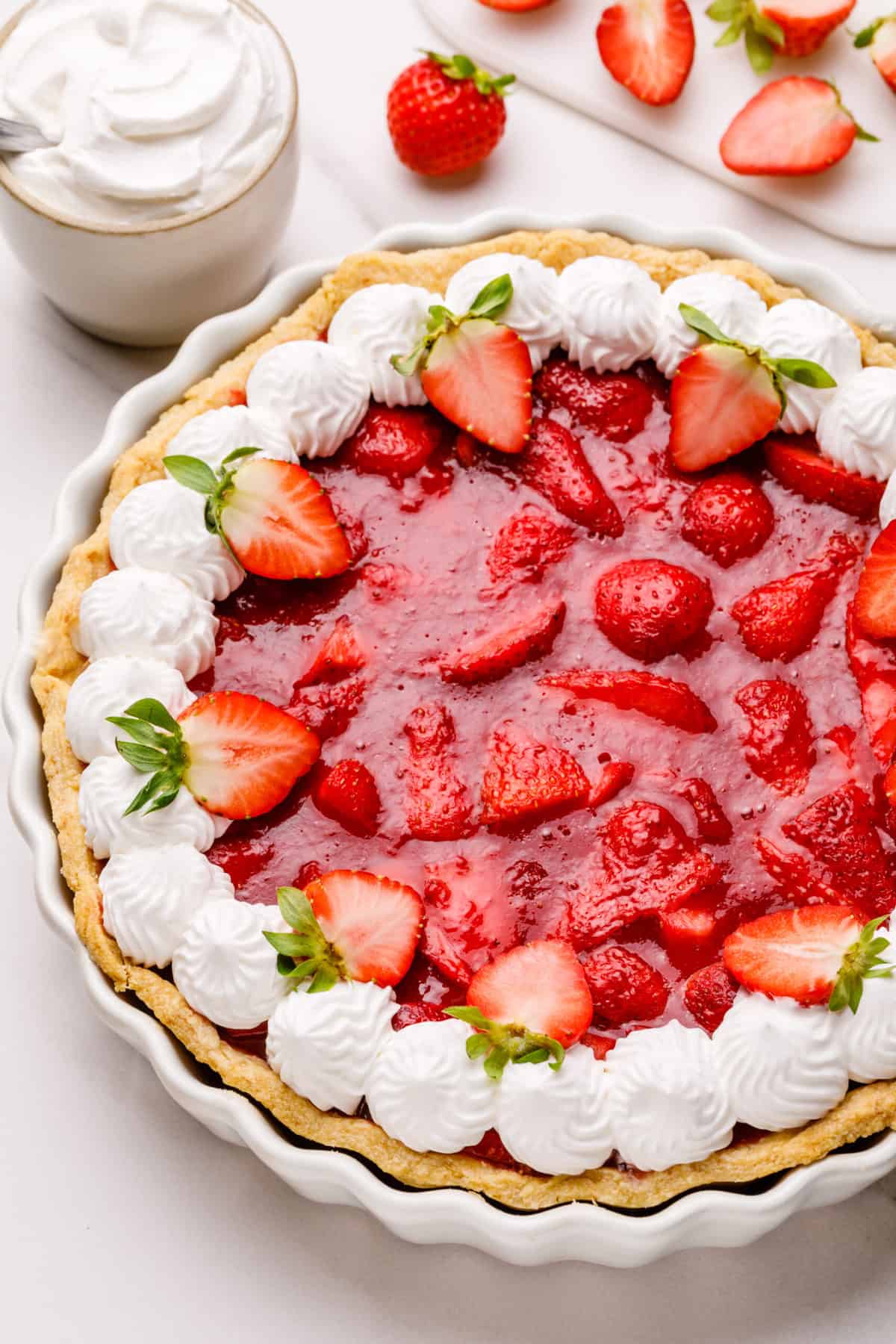 strawberry pie topped with fresh strawberries and chantilly cream