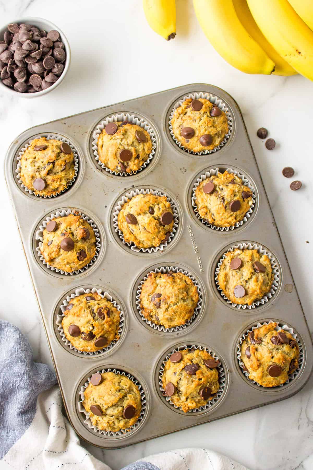 muffin tins with baked banana chocolate chip muffins