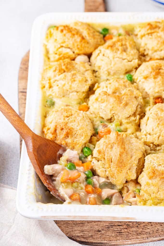 chicken and dumpling casserole in a table with a wooden spoon