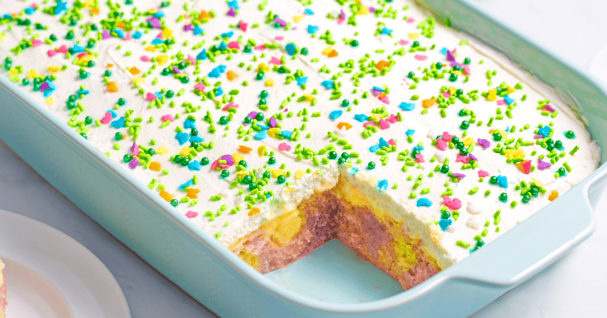 A baking dish of Easter poke cake with a slice missing.