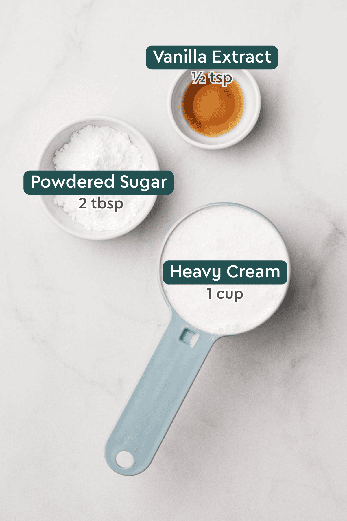 All of the ingredients for homemade whipped cream in bowls on a white counterop.