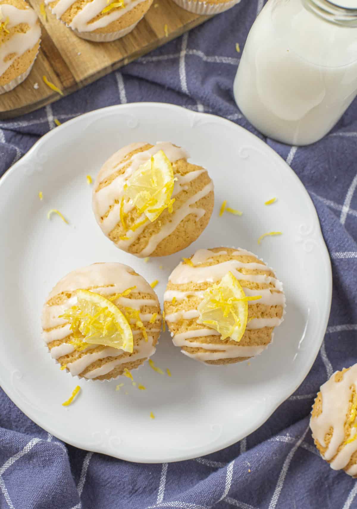 three lemon muffins with glaze served on a white plate