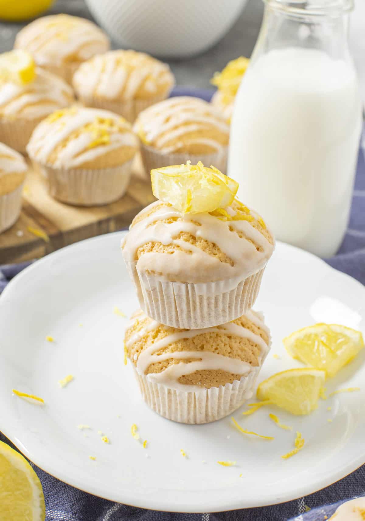 two lemon muffins stacked on a white plate