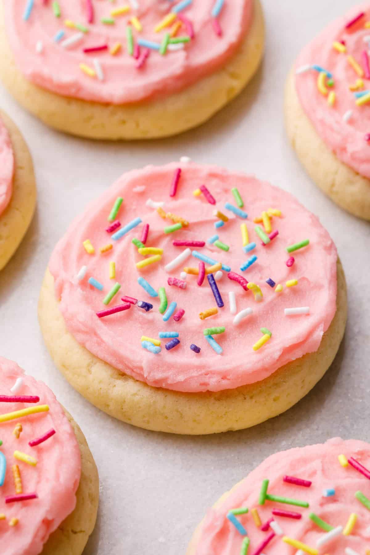 lofthouse cookies with pink frosting and rainbow sprinkles