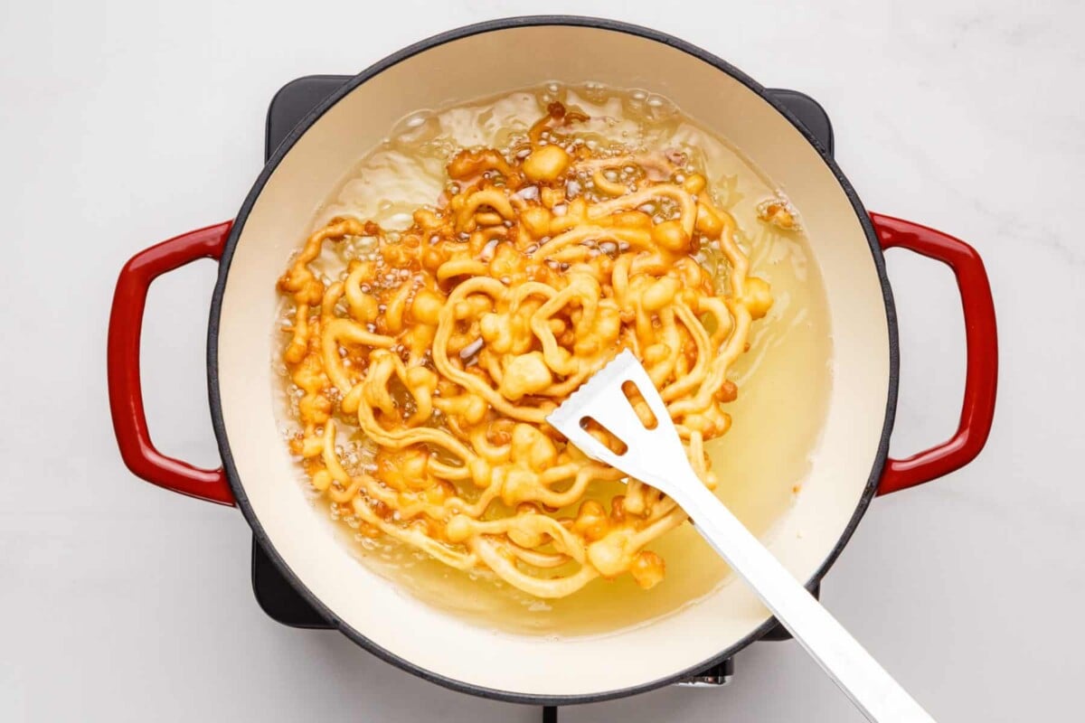 Pancake mix funnel cake cooking in Dutch oven.