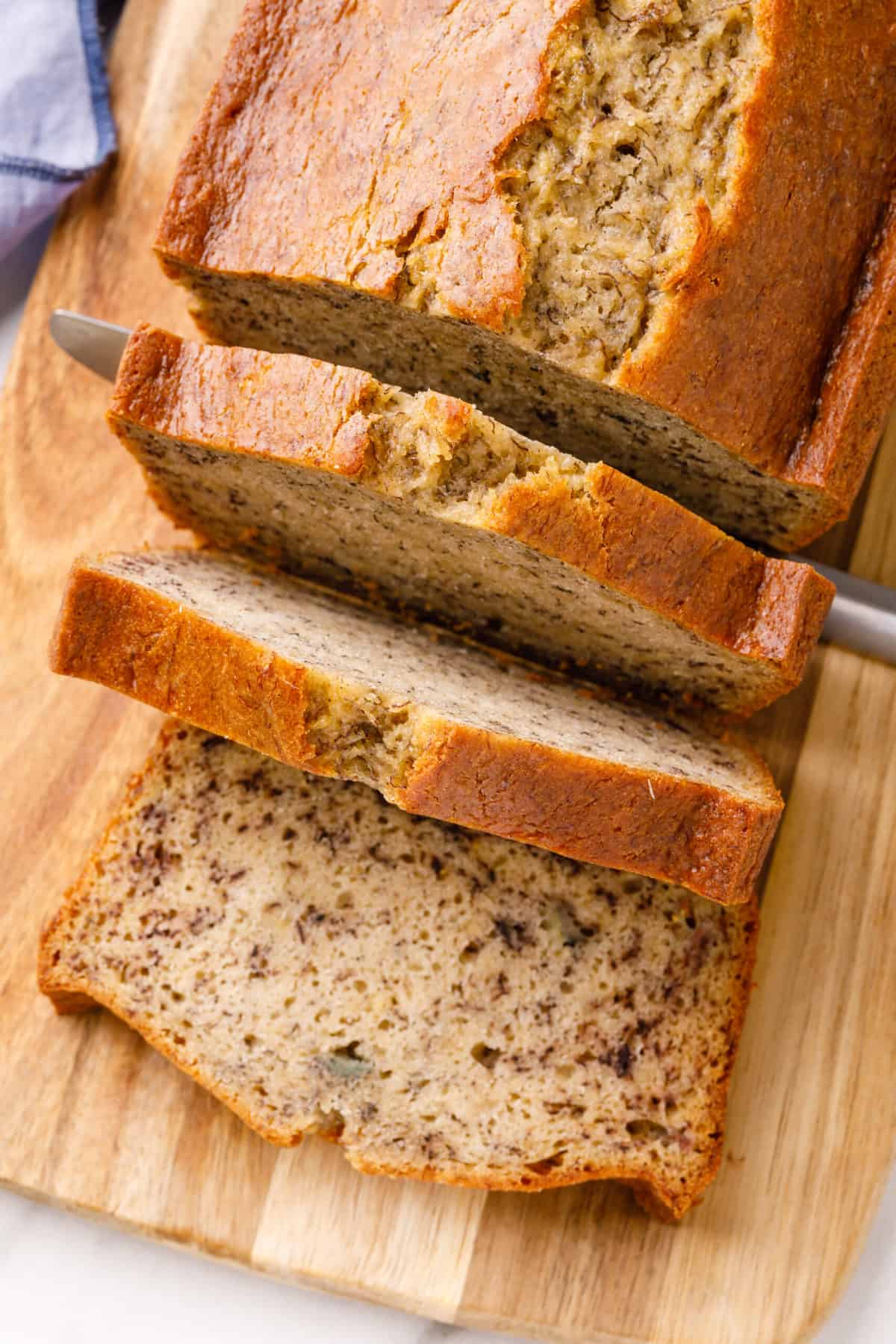 sour cream banana bread baked and sliced on a wooden board