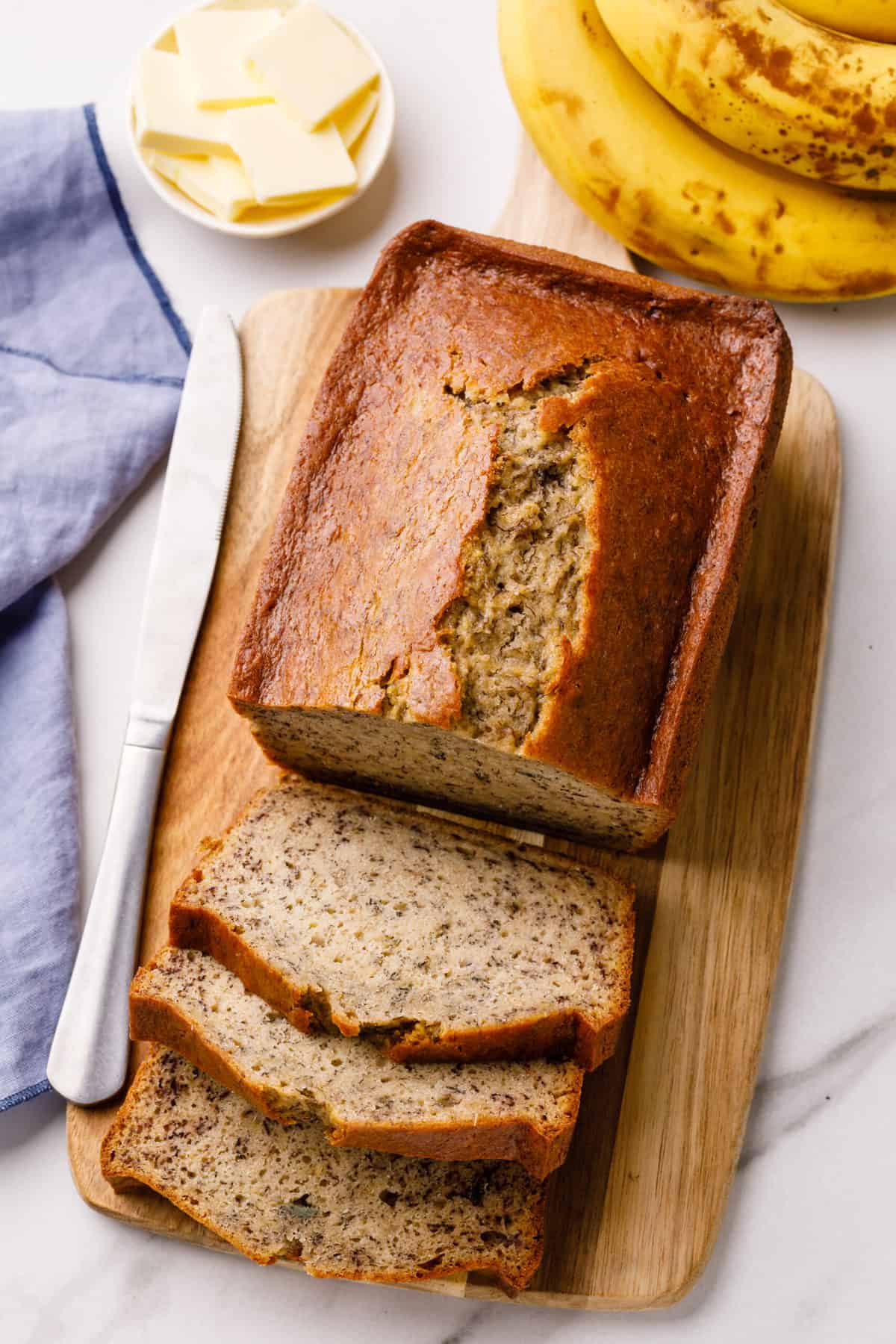 sour cream banana bread baked and sliced on a wooden board