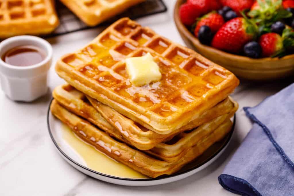 stack of square waffles with butter and syrup on top
