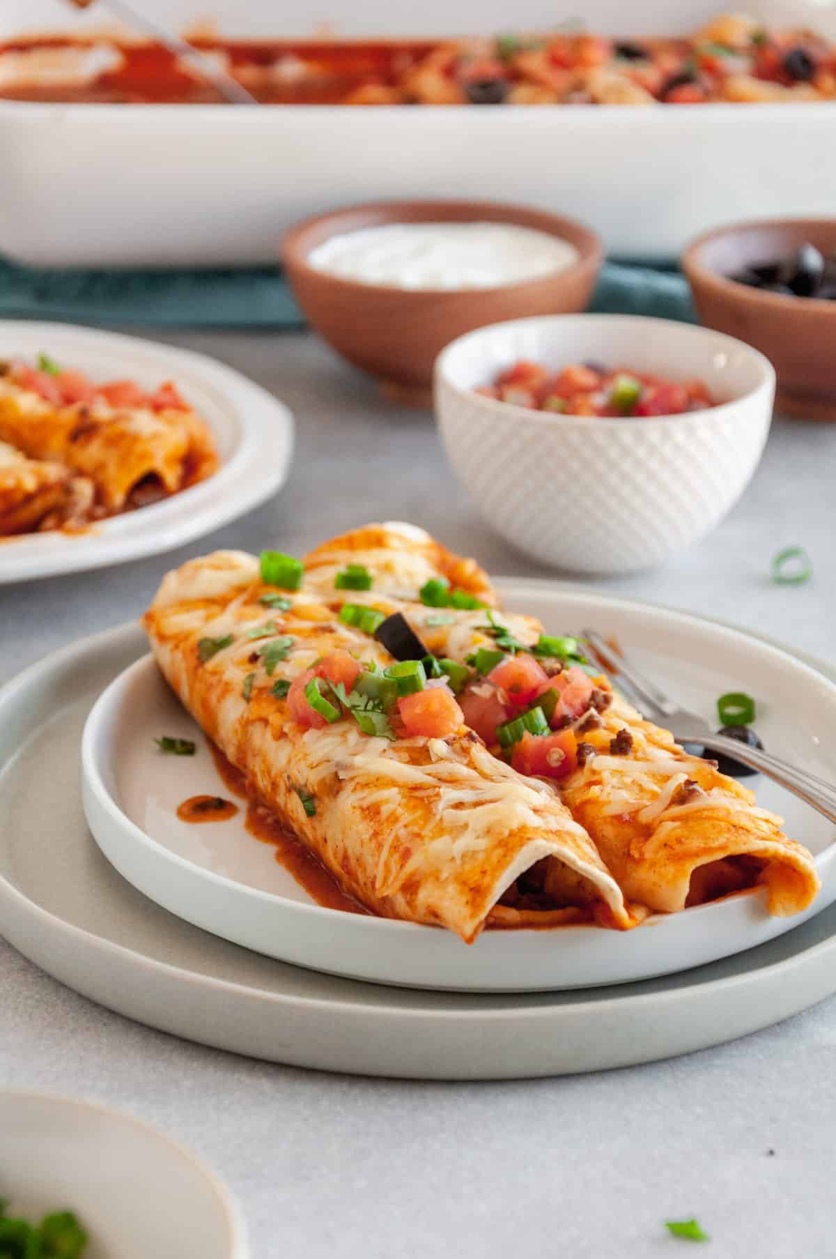 two beef enchiladas served on a plate