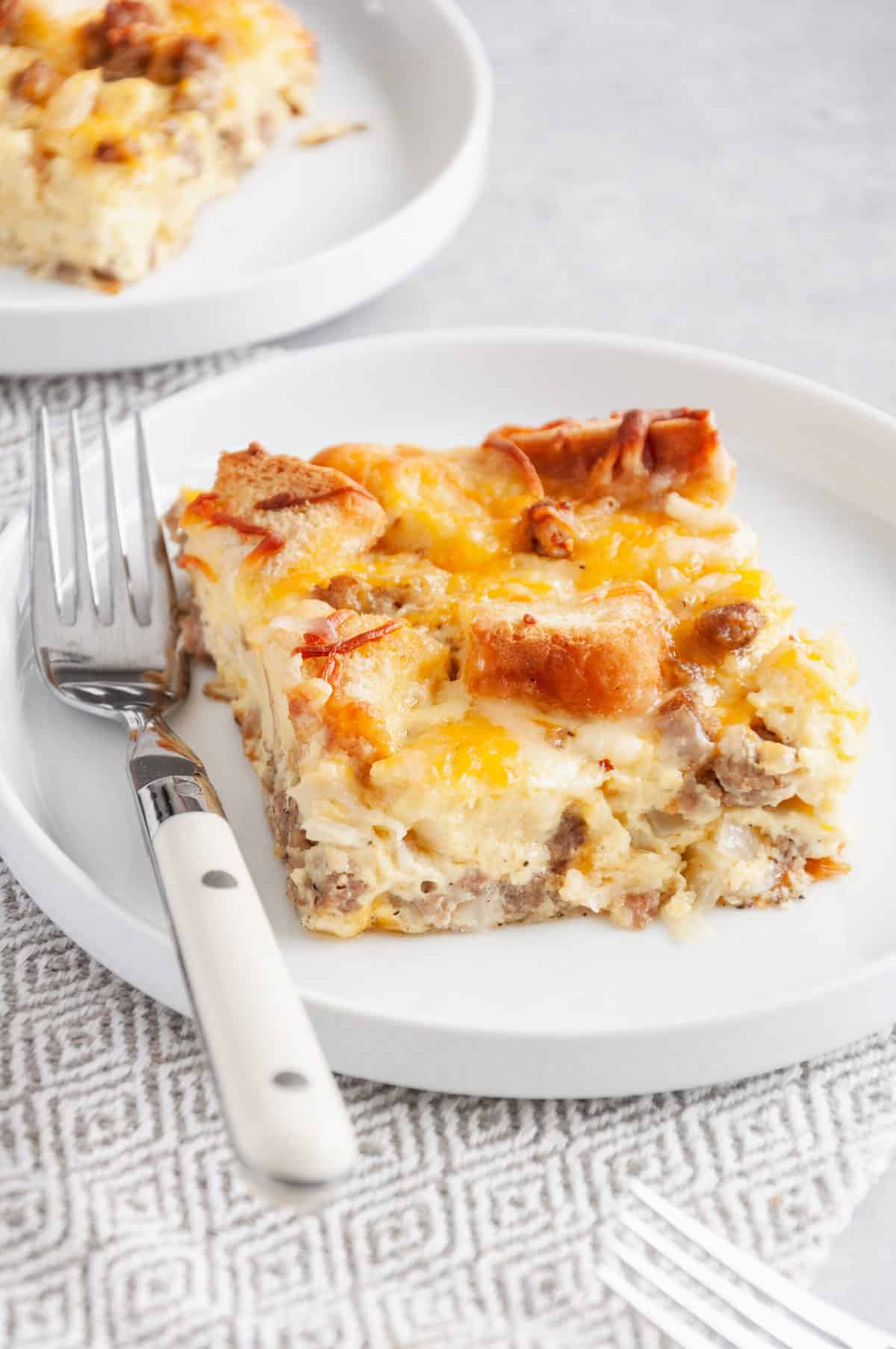slice serving of breakfast casserole with bread served on a plate