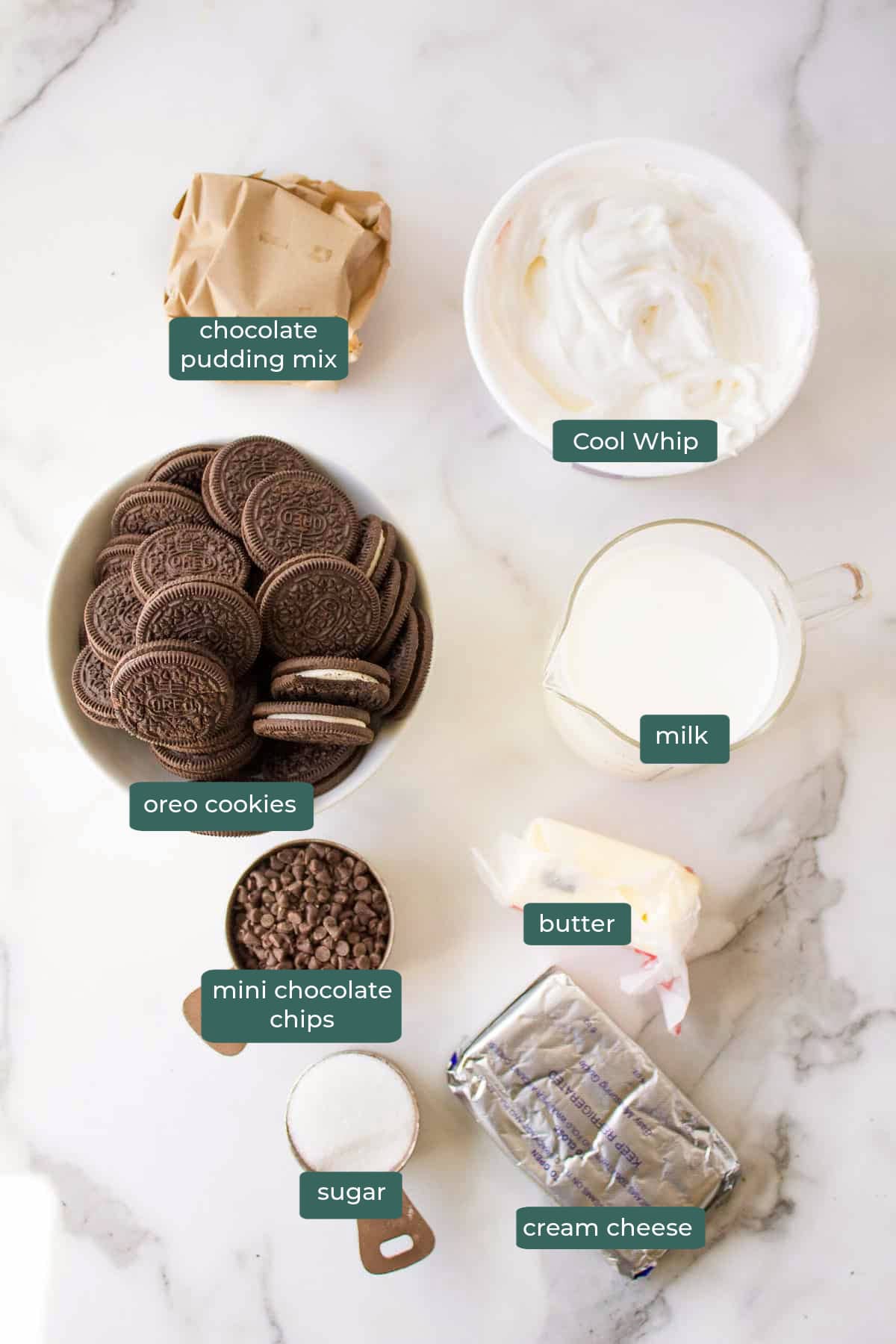 all of the ingredients for chocolate lasagna in bowls on a white countertop.