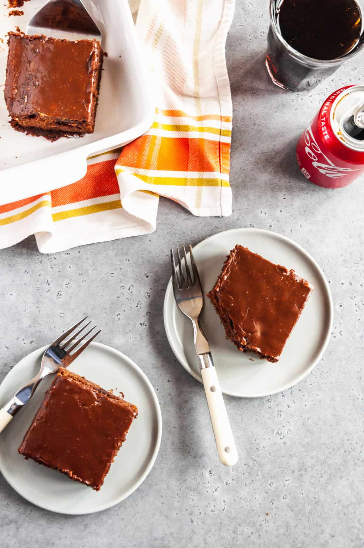 two serving of coca cola cake on a plate with forks