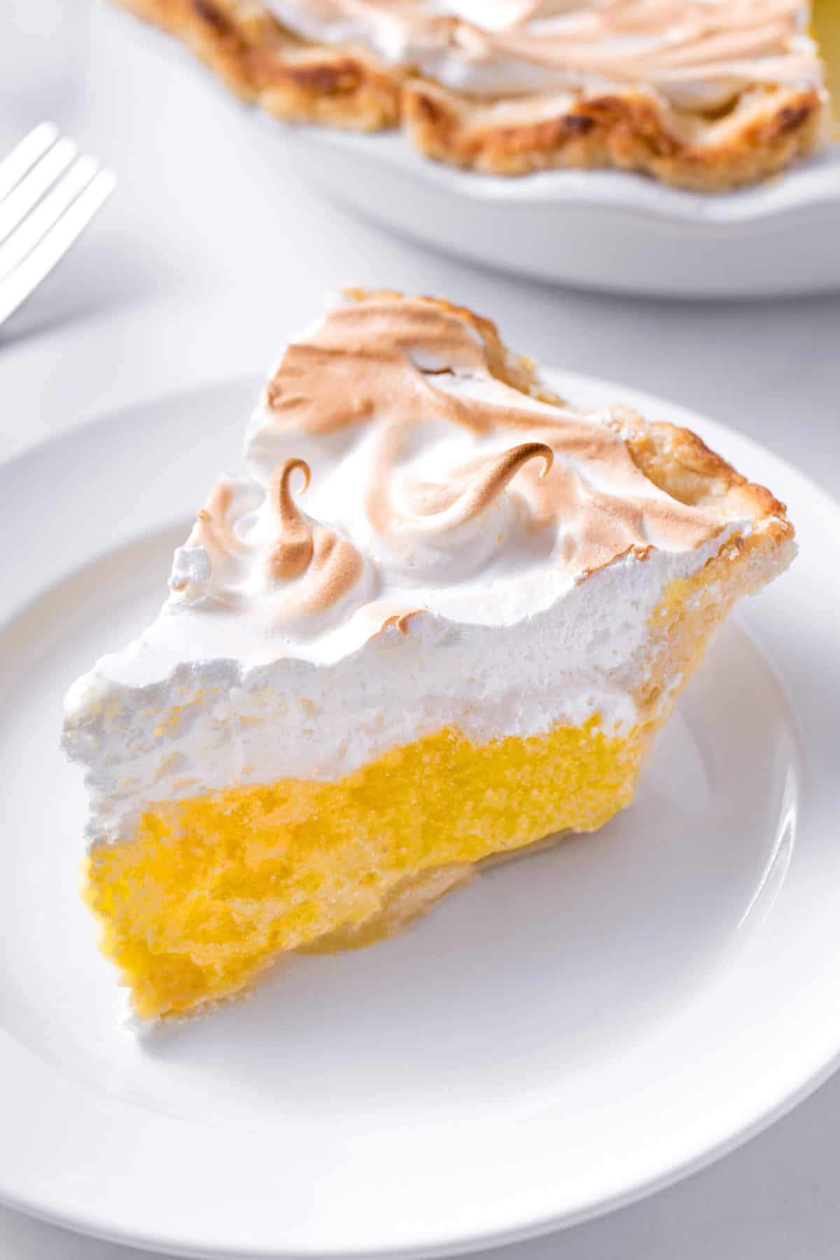slice of lemon meringue pie served on a white plate