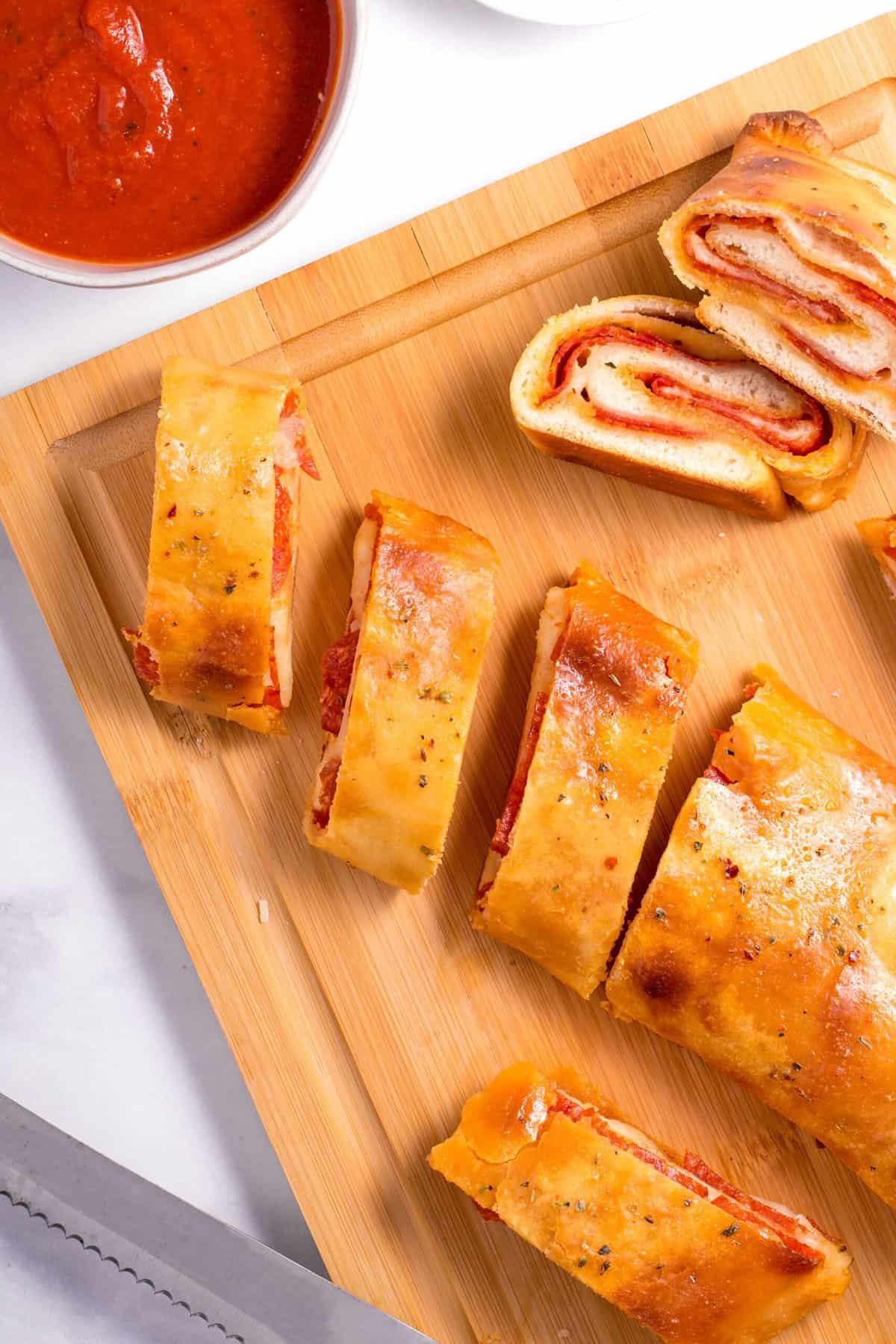 sliced pepperoni bread served on a wooden cutting board